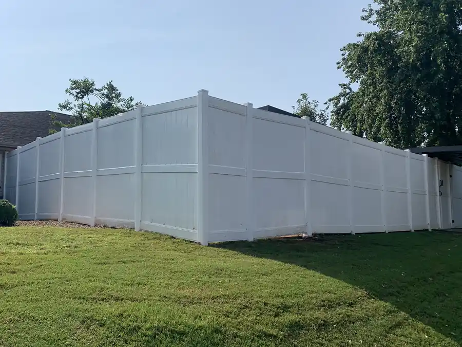 White vinyl privacy fence along a mown lawn