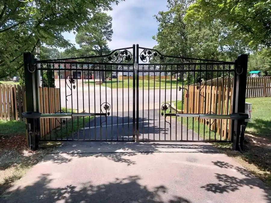Black ornamental double drive gate with grapevine scrollwork and gate operator arms in Fayetteville