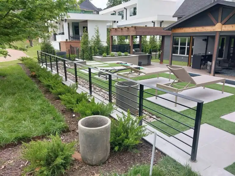 Black horizontal bar steel railing along a landscaped backyard in Rogers