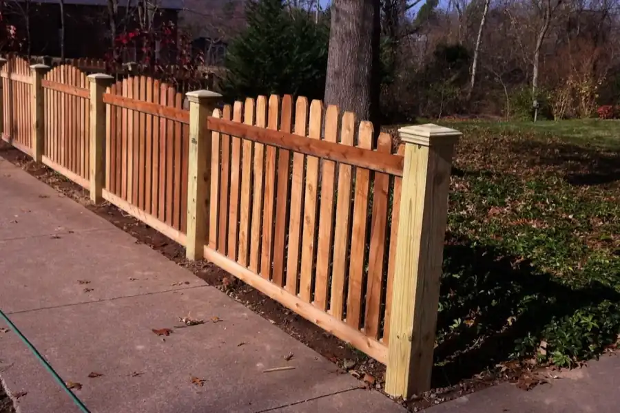 Scalloped cedar picket fence along a Fayetteville sidewalk